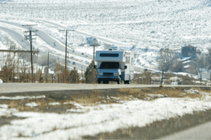 RV Winter Maintenance Checklist with Mevert Automotive & Tire Center in Steeleville, IL. image of rv van driving on road in the winter with snow covered ground