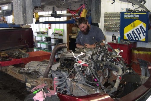 Powerstroke Diesel Service Recommendations in Steeleville, IL. Image of auto technician in an auto repair center working on Powerstroke diesel engine used in Ford trucks.